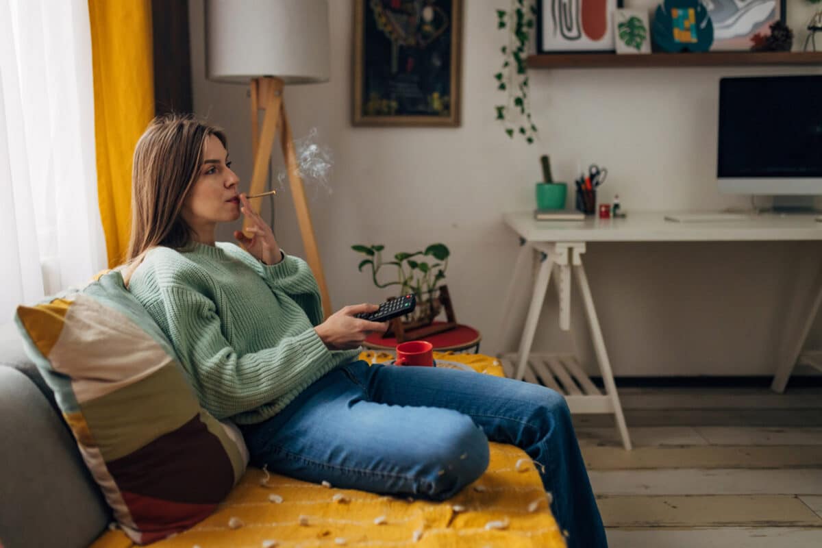 Photo of a happy mom holding a cannabis bouquet and gift box, celebrating a cannabis-themed Mother’s Day