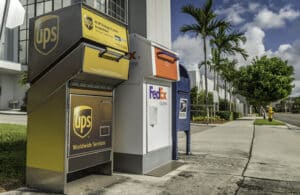 A row of drop off boxes for UPS, FedEx and USPS to represent a guide for businesses on shipping cannabis in the United States.
